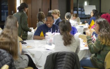 students smiling around a table