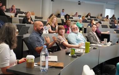 Conference participant speaking during keynote address.