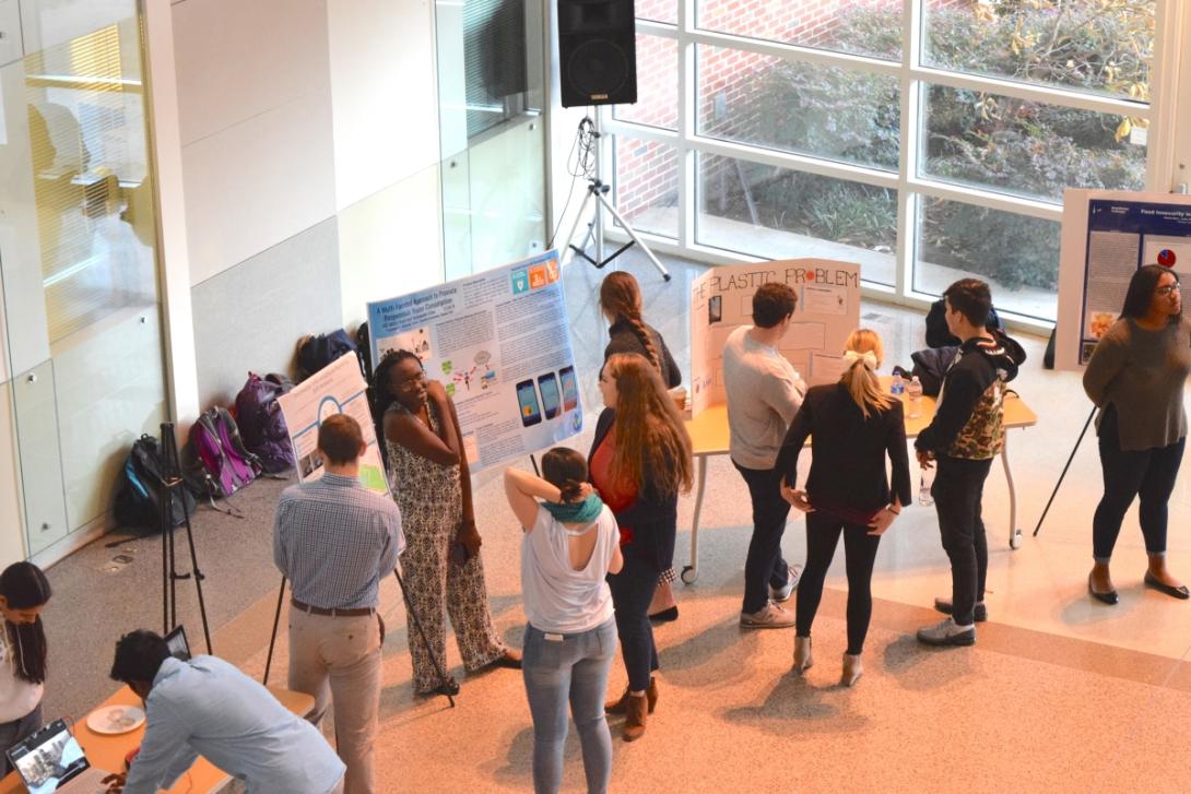 Students presenting their poster boards in a large room