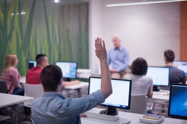 student raises hand in classroom